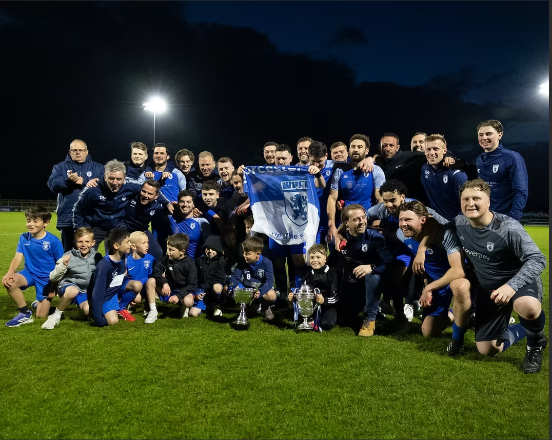 The Worcester Park FC squad and supporters together under the floodlights after winning the league
